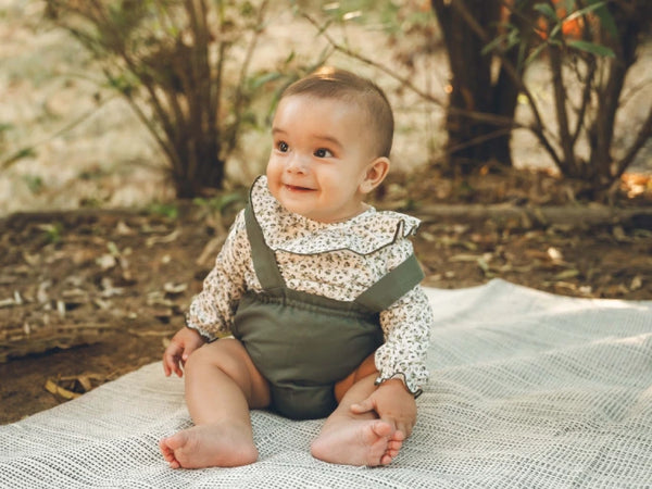 Bebé con cubrepañal con tirantes sarga verde Colección Álamo | MICŪ baby