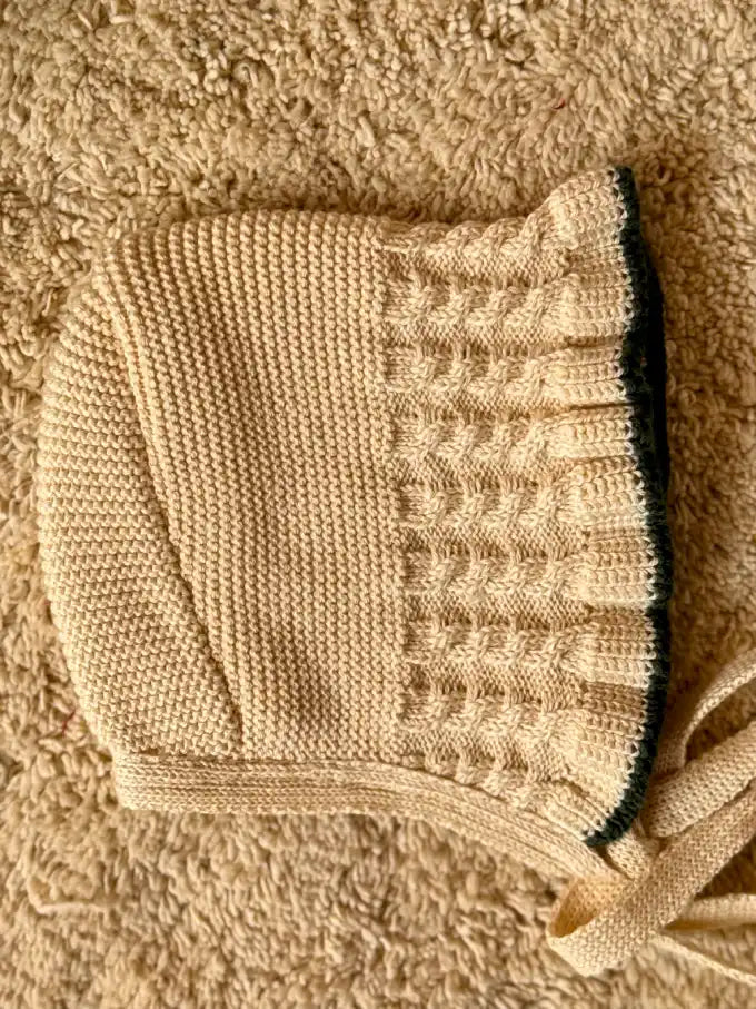Capota de punto crema con terminación en verde pino - Colección Camomila