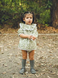 Niña de frente con Jesusito manga larga verde con flores blancas Colección Helecho | MICŪ baby
