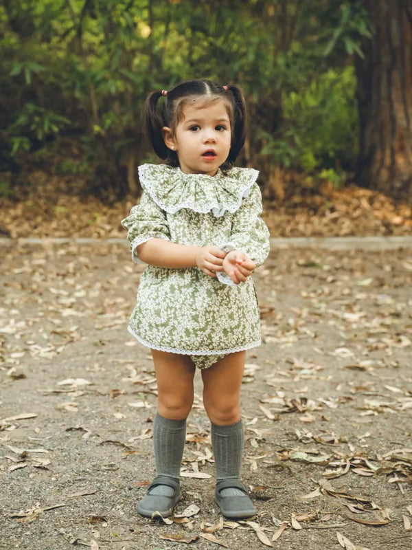 Niña de frente con Jesusito manga larga verde con flores blancas Colección Helecho | MICŪ baby