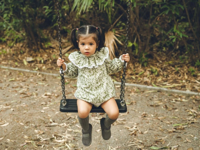 Niña sentada con Jesusito manga larga verde con flores blancas Colección Helecho | MICŪ baby