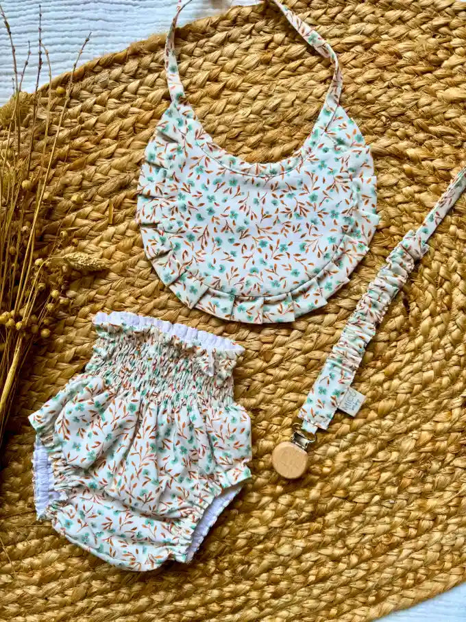 Pack cubrepañal, babero y chupetero con estampado de flores verde agua y mostaza Eucalipto