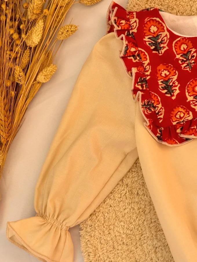 Pelele beige con cuello baberola con estampado floral rojo - Colección Loto